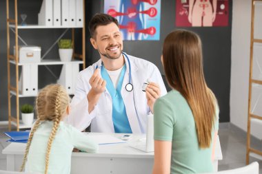 Anne ve kızı klinikte endokrinoloğu ziyaret ediyor.