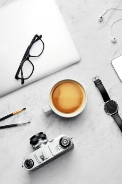 Beyaz arka planda bir fincan kahve, laptop ve fotoğraf makinesi ile kompozisyon