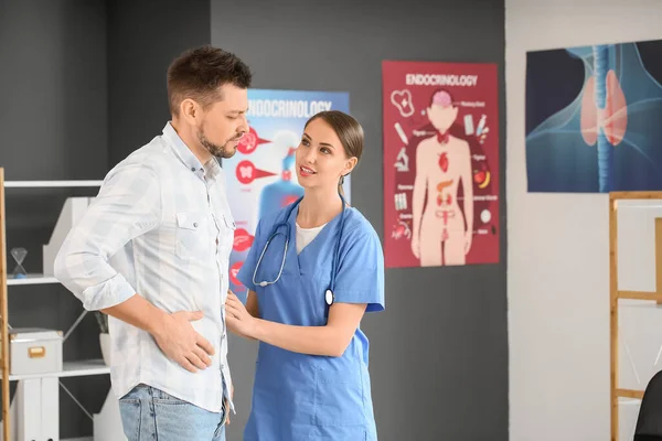 Doctor examining man with problem in clinic