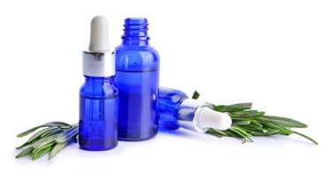 Beyaz arka planda biberiye yağı şişeleri