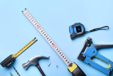 Renkli arka planda inşaatçının malzemeleriyle mezuraları ölçmek