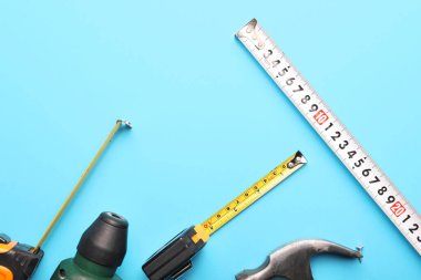 Renkli arka planda inşaatçının malzemeleriyle mezuraları ölçmek