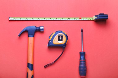 Renkli arka planda inşaatçının malzemeleriyle mezuraları ölçmek