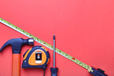 Renkli arka planda inşaatçının malzemeleriyle mezuraları ölçmek