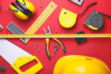 Renkli arka planda inşaatçının malzemeleriyle şerit ölçümü