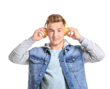 Genç adam beyaz arka planda müzik dinliyor.
