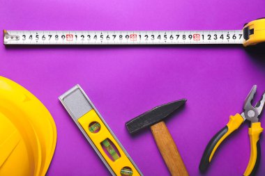 Renkli arka planda inşaatçının malzemeleriyle şerit ölçümü