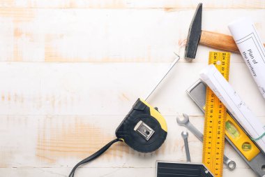 İnşaat malzemeleri ve ahşap arka plandaki planlarla şerit ölçülüyor.