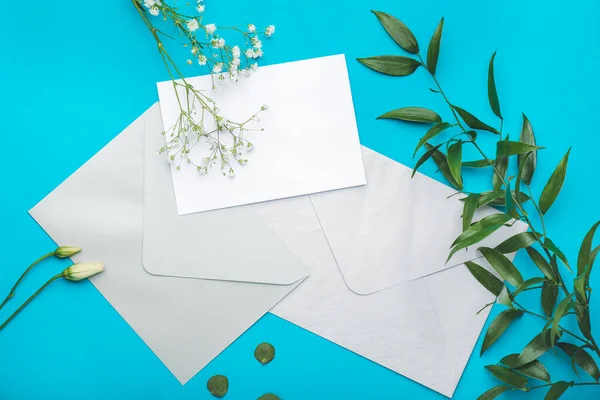 Composition with blank card and envelopes on color background