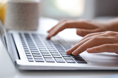 Evde online öğrenim için dizüstü bilgisayar kullanan genç bir kadın