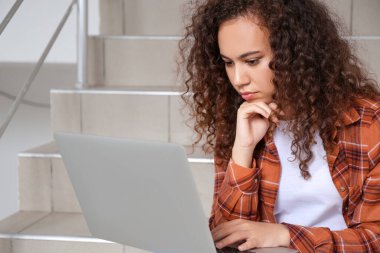 Genç kadın çevrimiçi öğrenim için dizüstü bilgisayar kullanıyor