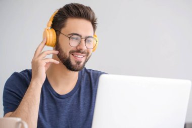 Genç adam evde online öğrenim için dizüstü bilgisayar kullanıyor