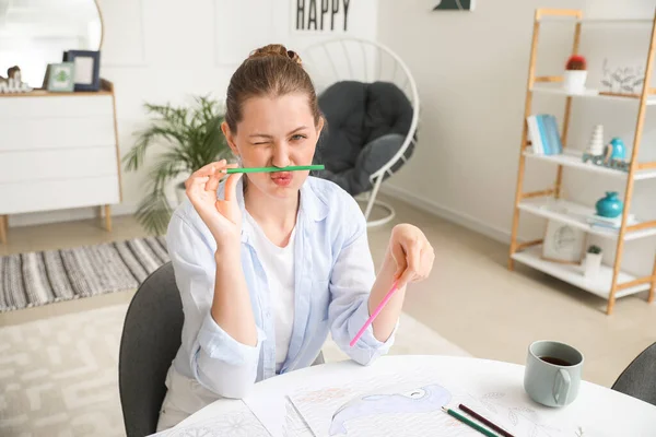 Funny woman coloring picture at home