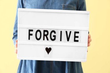 Sözcüklü pano tutan kadın. Renk arkaplanı, kapat.