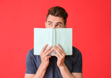 Renklerle ilgili kitabı olan düşünceli bir genç adam.