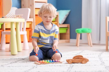 Anaokulunda oynayan sevimli küçük çocuk.