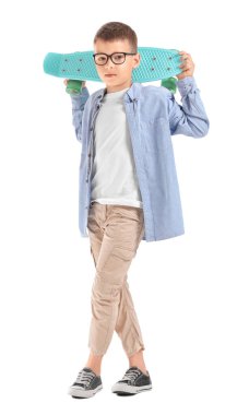 Beyaz arka planda kaykayı olan şirin bir çocuk.