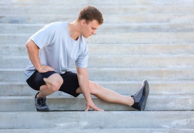 Sportif genç adam dışarıda antrenman yapıyor.