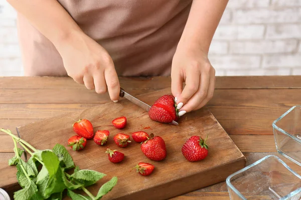 Kadın mutfakta tatlı çilek reçeli yapıyor.