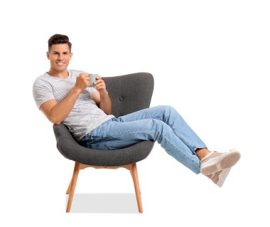 Kahveli genç adam beyaz arka planda koltukta dinleniyor.