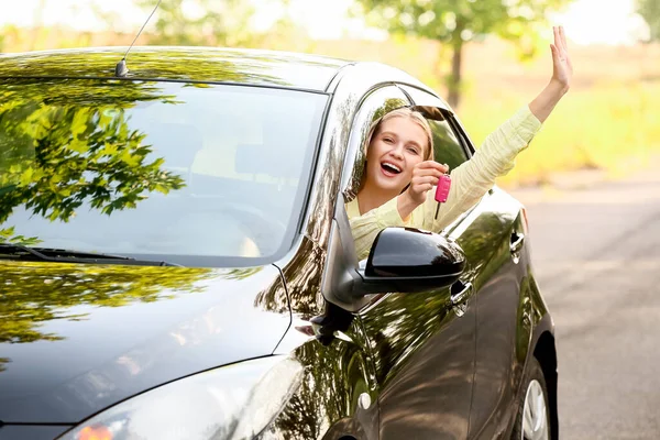 幸せな若いです女性とともにキー座っています新しい車 — ストック写真