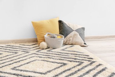 İçinde sepet, yastık ve güzel halı olan modern bir oda.