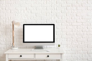 Modern bilgisayar ışık duvarının yanındaki masada.