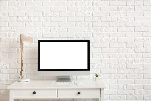 Modern bilgisayar ışık duvarının yanındaki masada.