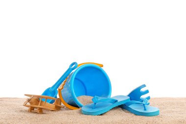 Beyaz arka planda kumdaki çocuklar için plaj aksesuarları