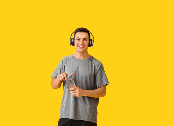 Joven Deportivo Con Botella Agua Auriculares Sobre Fondo Color — Foto de Stock