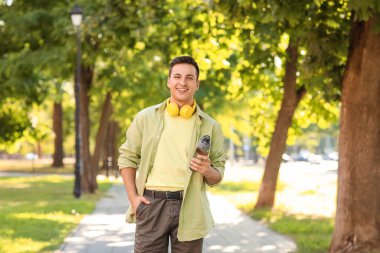 Parkta elinde su şişesi olan genç bir adam.