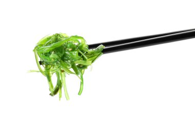 Beyaz arka planda lezzetli deniz yosunu salatası olan çubuklar.