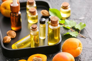 Kayısı şişeleri koyu arkaplanda gerekli yağ