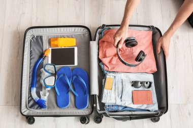 Evinde bavul hazırlayan bir adam. Seyahat kavramı