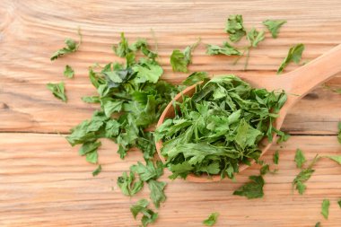 Tahta arka planda kuru maydanozlu kaşık