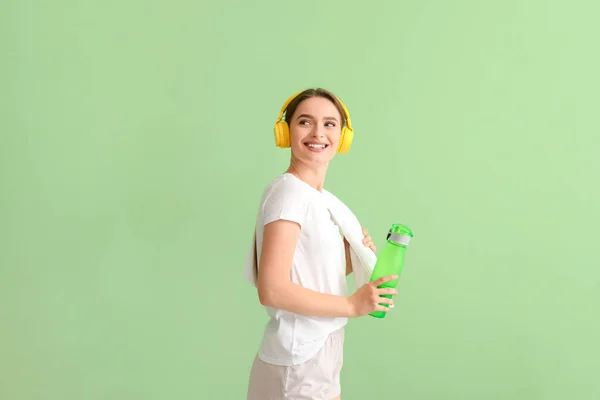 Mujer Joven Deportiva Con Auriculares Agua Sobre Fondo Color —  Fotos de Stock