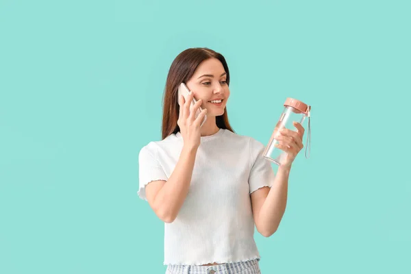 Młoda Kobieta Butelką Wody Rozmawia Przez Telefon Tle Koloru — Zdjęcie stockowe