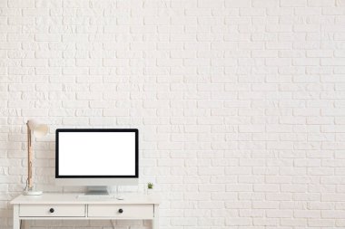 Modern bilgisayar ışık duvarının yanındaki masada.