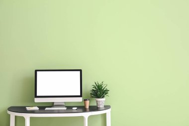 Renk duvarına yakın masadaki modern bilgisayar