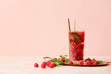 Arka planda bir bardak soğuk ahududu çayı