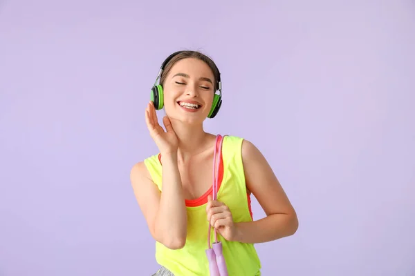 Sportliche Junge Frau Mit Kopfhörern Und Springseil Auf Farbigem Hintergrund — Stockfoto