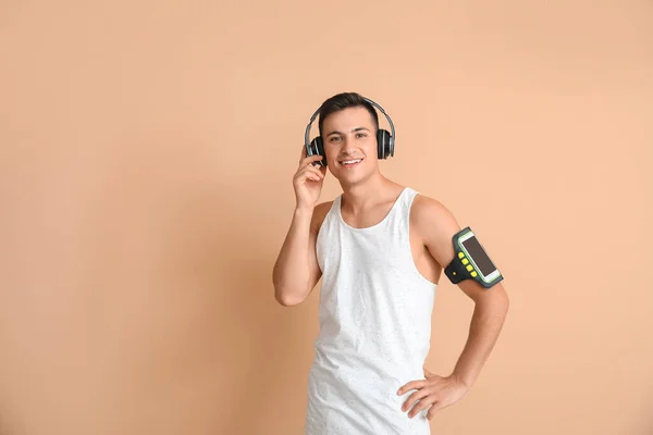 Joven Deportivo Con Auriculares Sobre Fondo Color — Foto de Stock