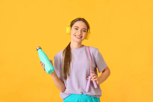 Mujer Joven Deportiva Con Auriculares Agua Sobre Fondo Color — Foto de Stock