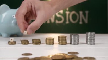 Yığılmış madeni paralar ve masanın üzerindeki Kelime PENSION ile kompozisyon