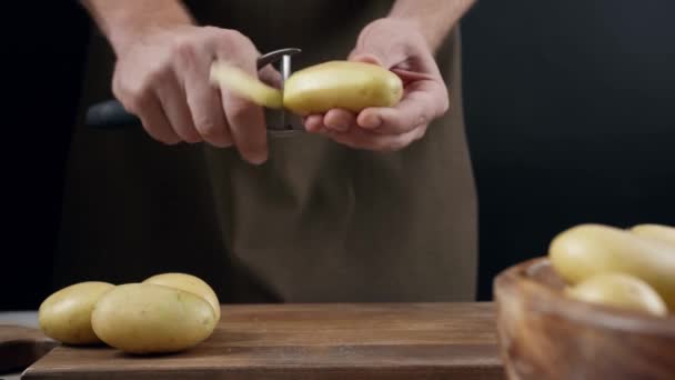 Homme Épluchant Des Pommes Terre Crues Sur Fond Sombre Gros — Video