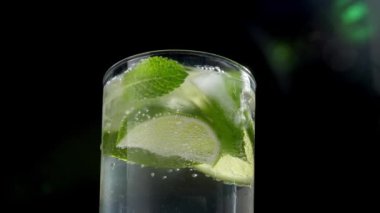 Karanlık arka planda bir bardak taze mojito, yakın plan.