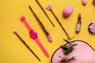 Renk arkaplanında kozmetik çantalı kompozisyon