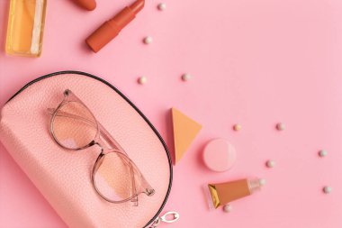 Renk arkaplanında kozmetik çantalı kompozisyon