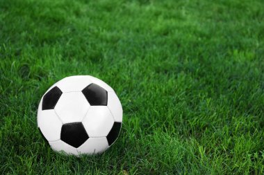 Yeşil çimlerin üzerinde futbol topu.