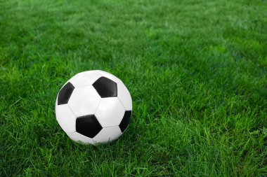 Yeşil çimlerin üzerinde futbol topu.